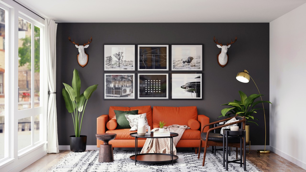 Elegantly comfortable living room with black and white prints, gray and white paint highlighted by an orange couch.